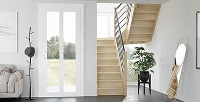 Imagen de un interior moderno y luminoso con una escalera de madera a medida que conduce al piso superior.
